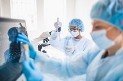 Lab technicians inserting fluid with pipet