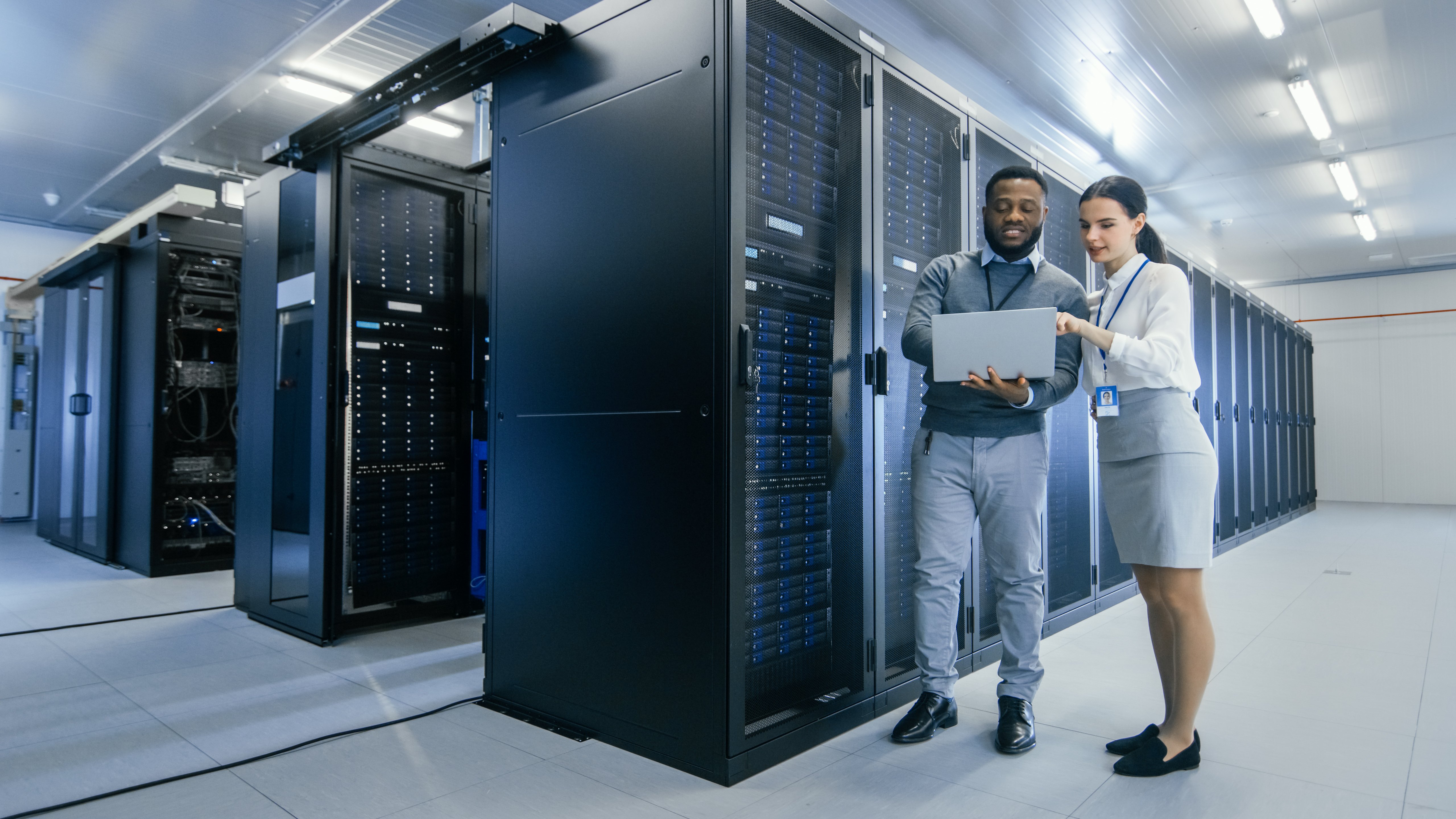 Technicians reviewing server racks inside a modern data center during construction and commissioning.