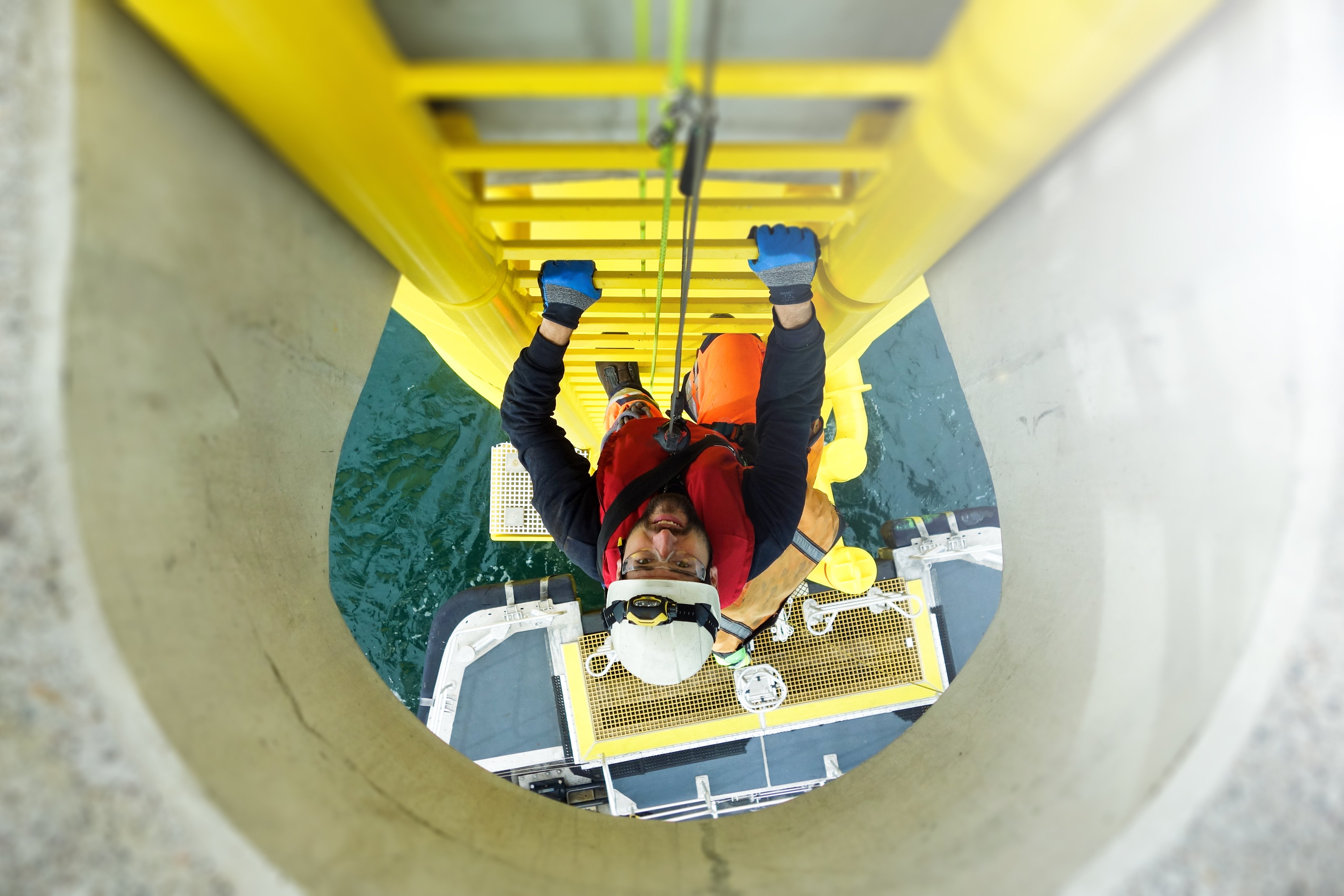 Offshore rig worker climbing a ladder structure on an offshore oil platform