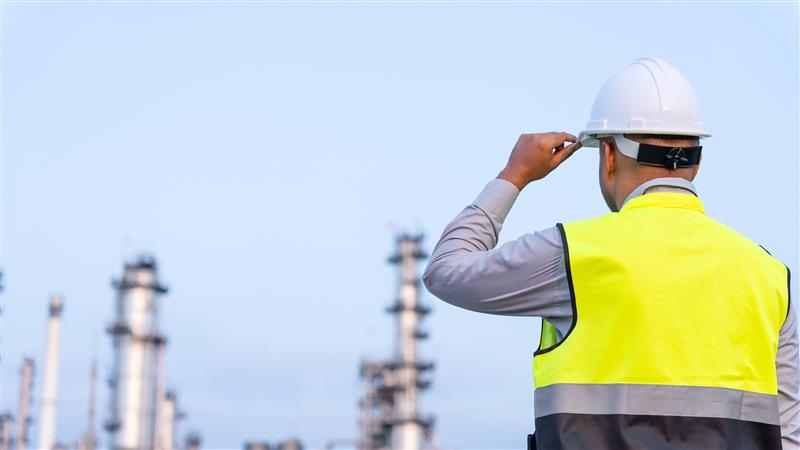 Offshore oil rigger inspecting oil and gas infrastructure at an industrial facility