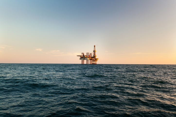 Offshore oil rig platform in open water at sunset representing offshore oil rig jobs and offshore oil drilling jobs