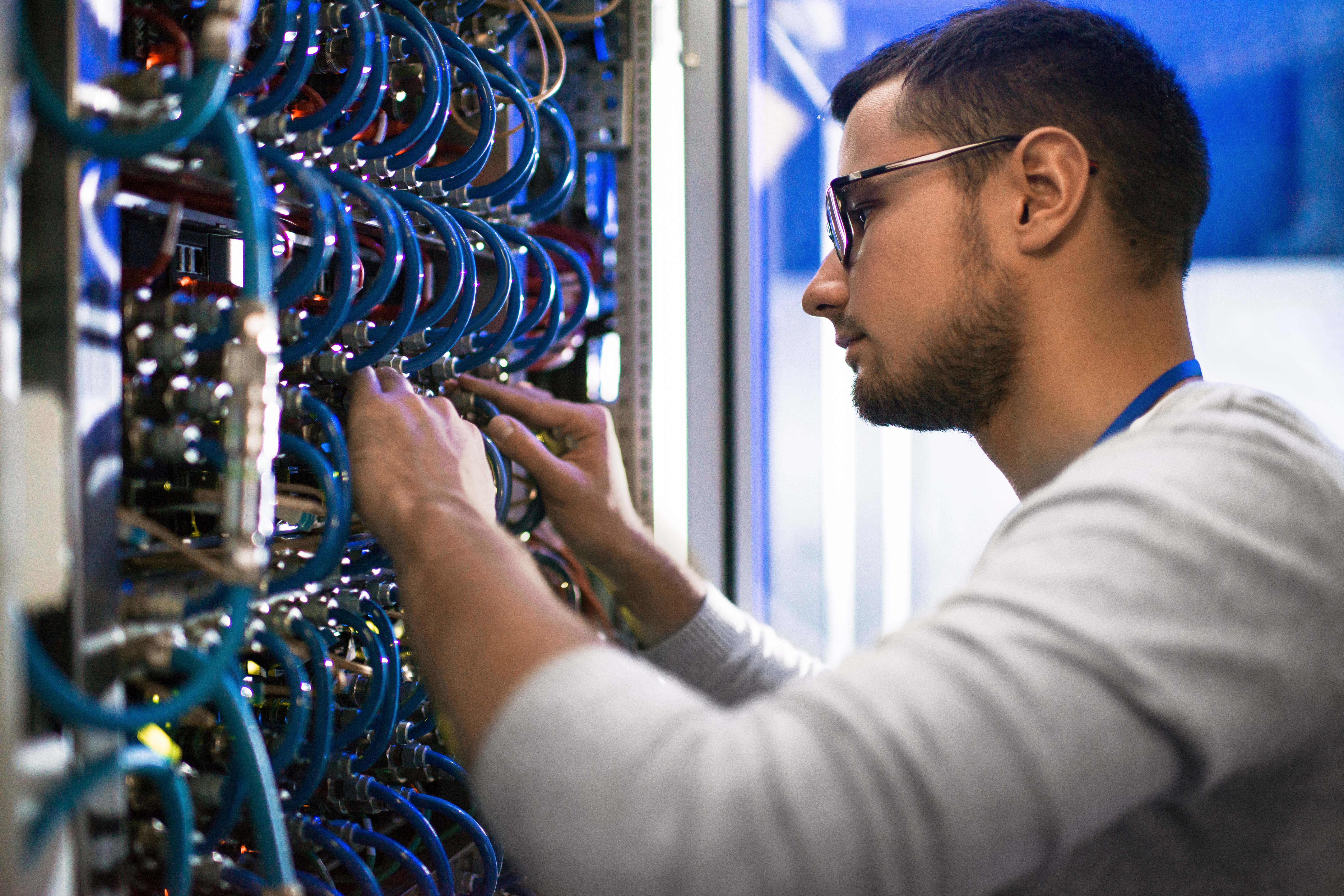 Technician installing structured cabling in a data center during construction and infrastructure setup.