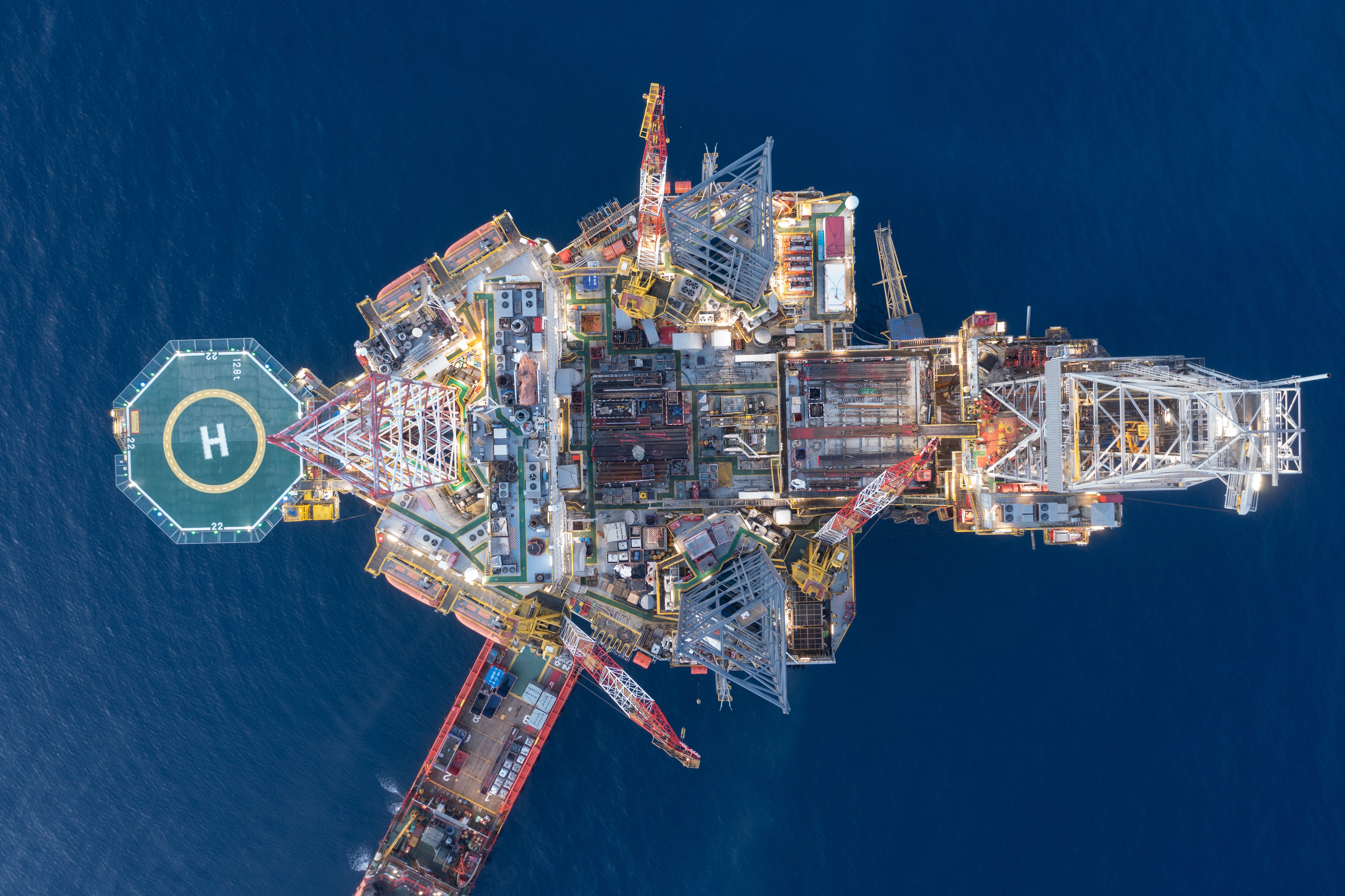 Aerial view of an offshore oil platform with a helipad used to transport oil rig workers during crew changes and offshore rotations.