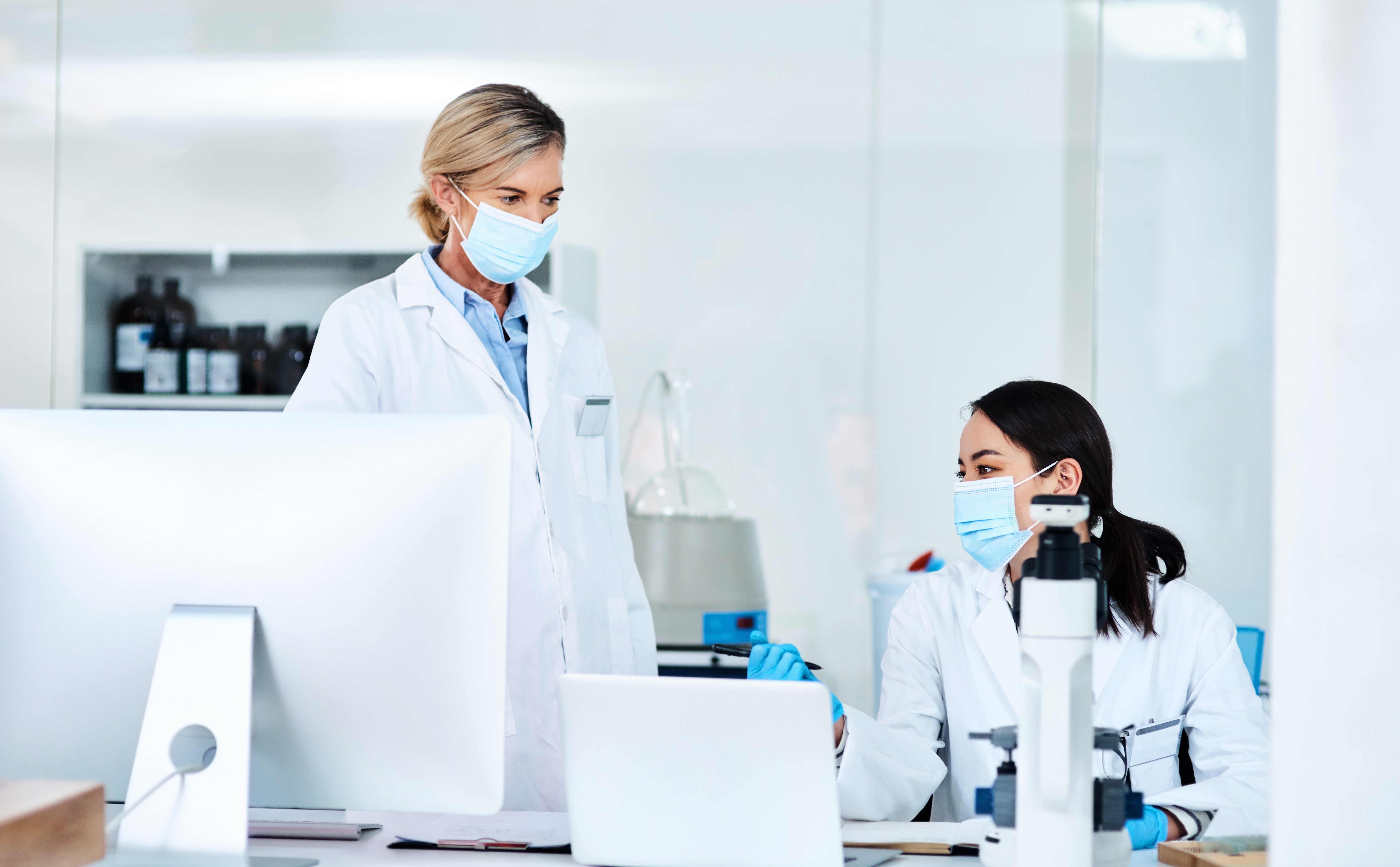 Two scientists discussing laboratory results at a workstation, highlighting communication responsibilities in medical science liaison jobs.