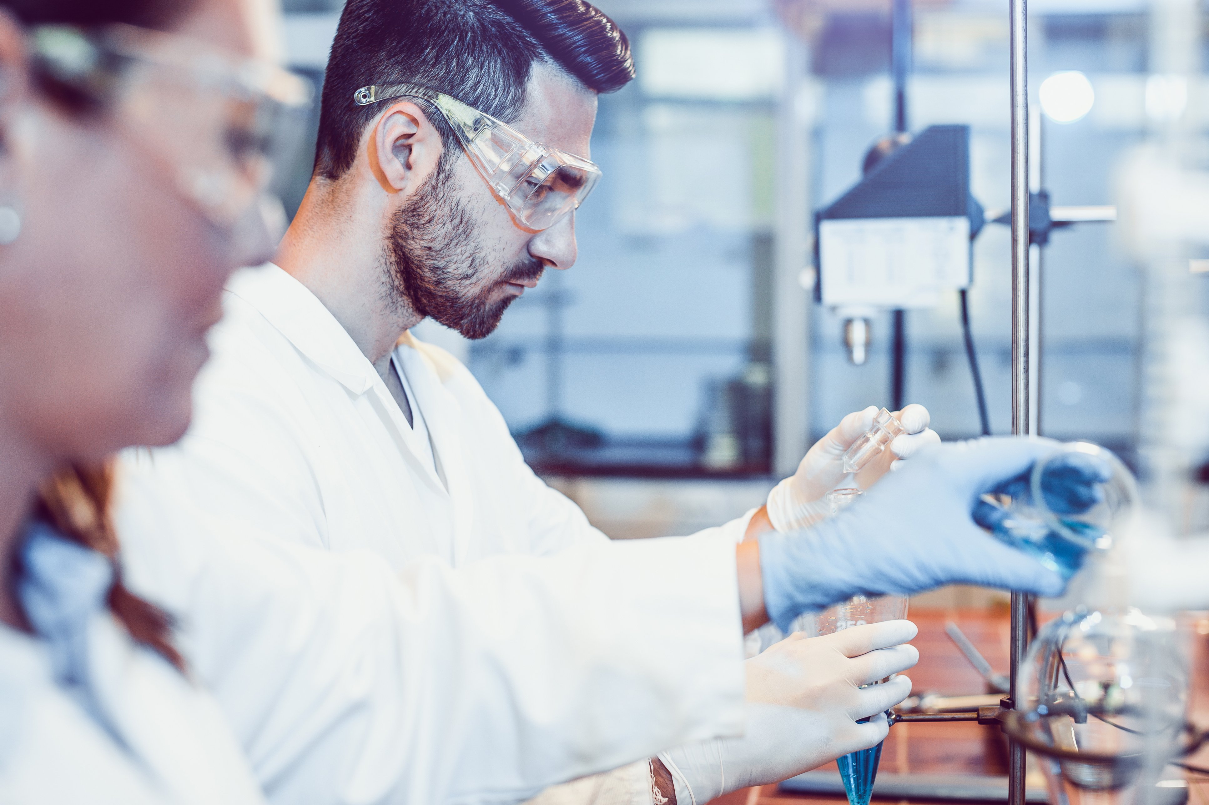 Scientists working with lab equipment to prepare research samples, representing scientific collaboration common in medical science liaison jobs.