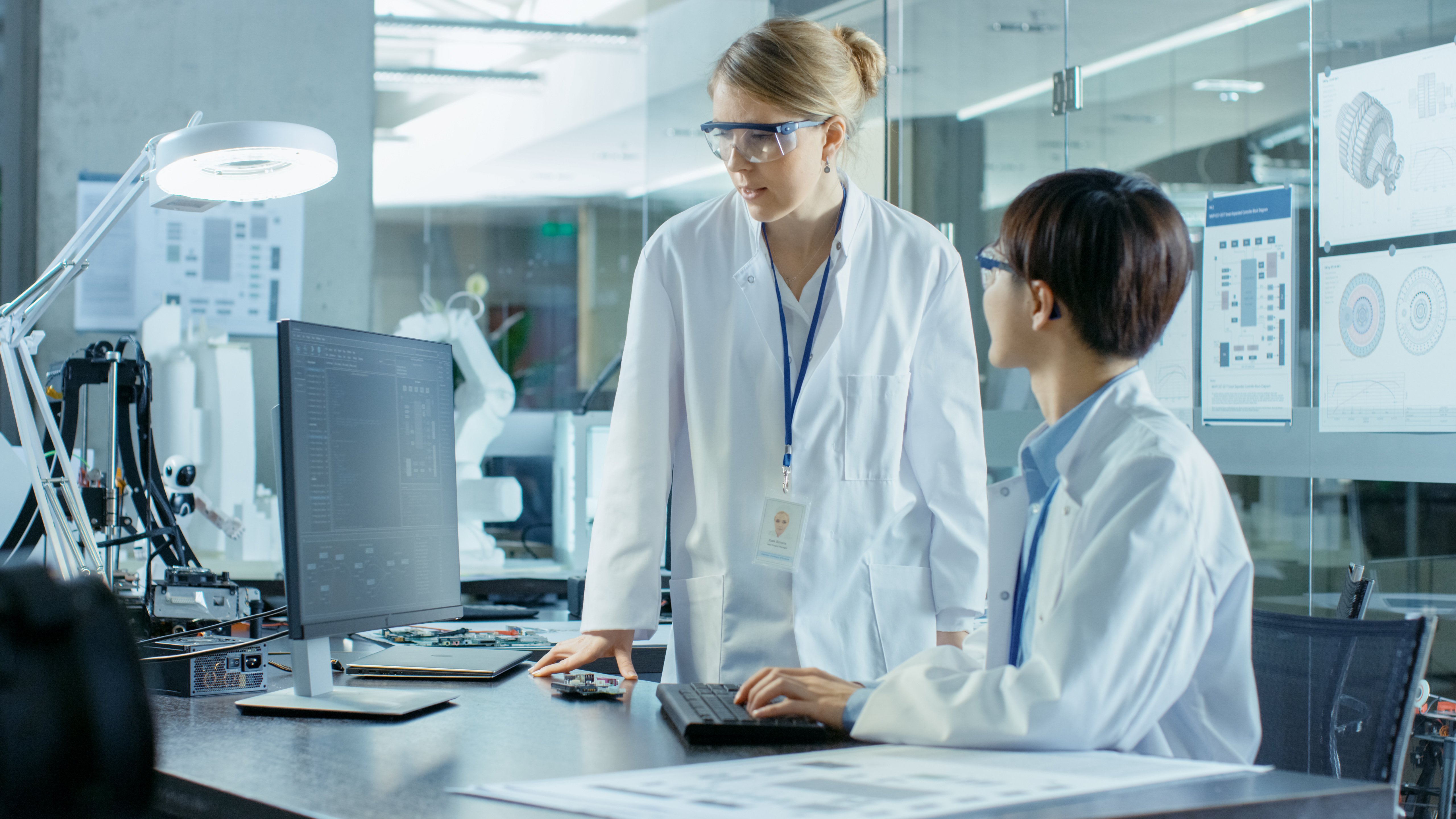 Two scientists reviewing data on a computer in a modern research lab, illustrating teamwork and communication essential for medical science liaison careers.