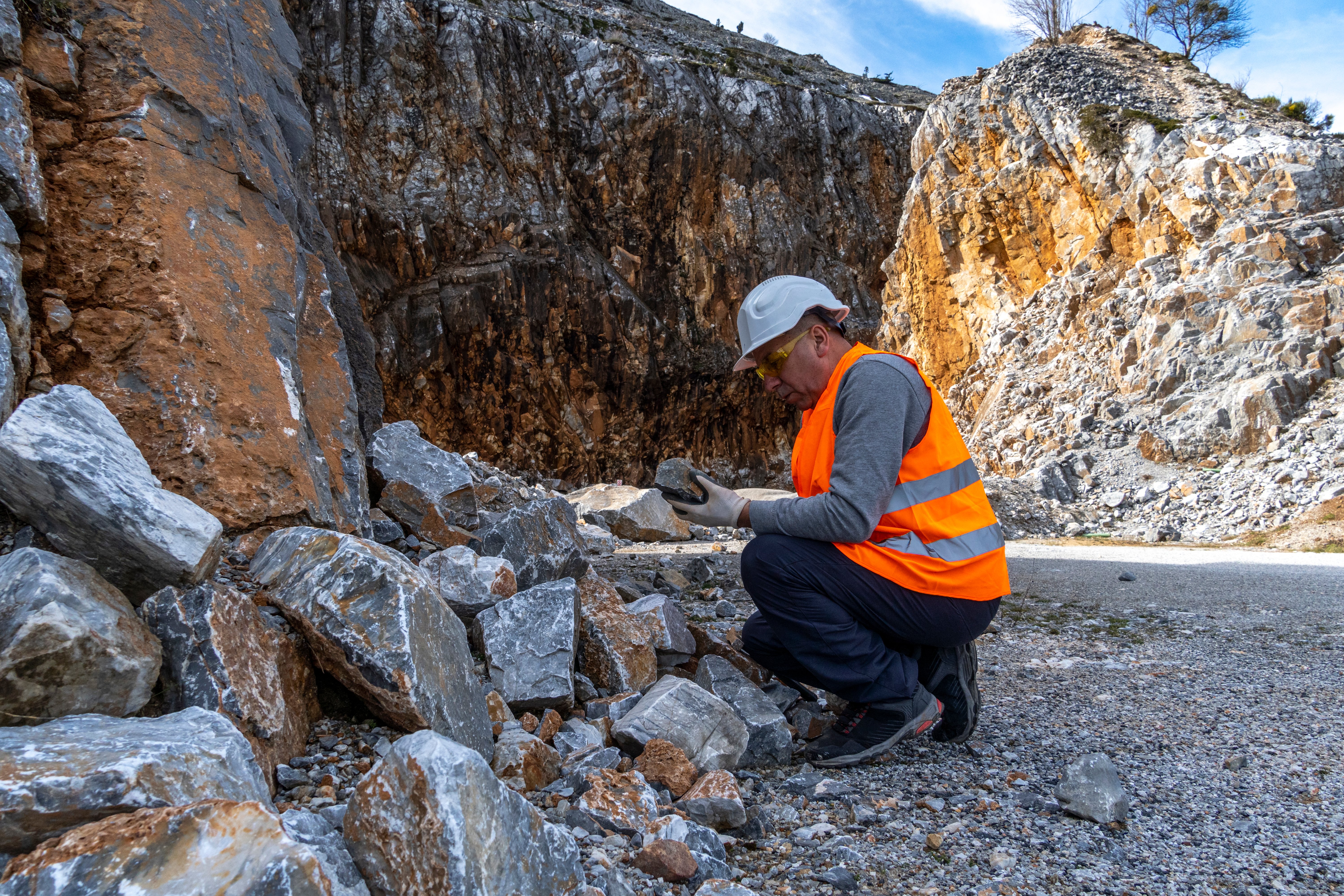 worker inspecting rock in surface mining site related to mountaintop removal mining method