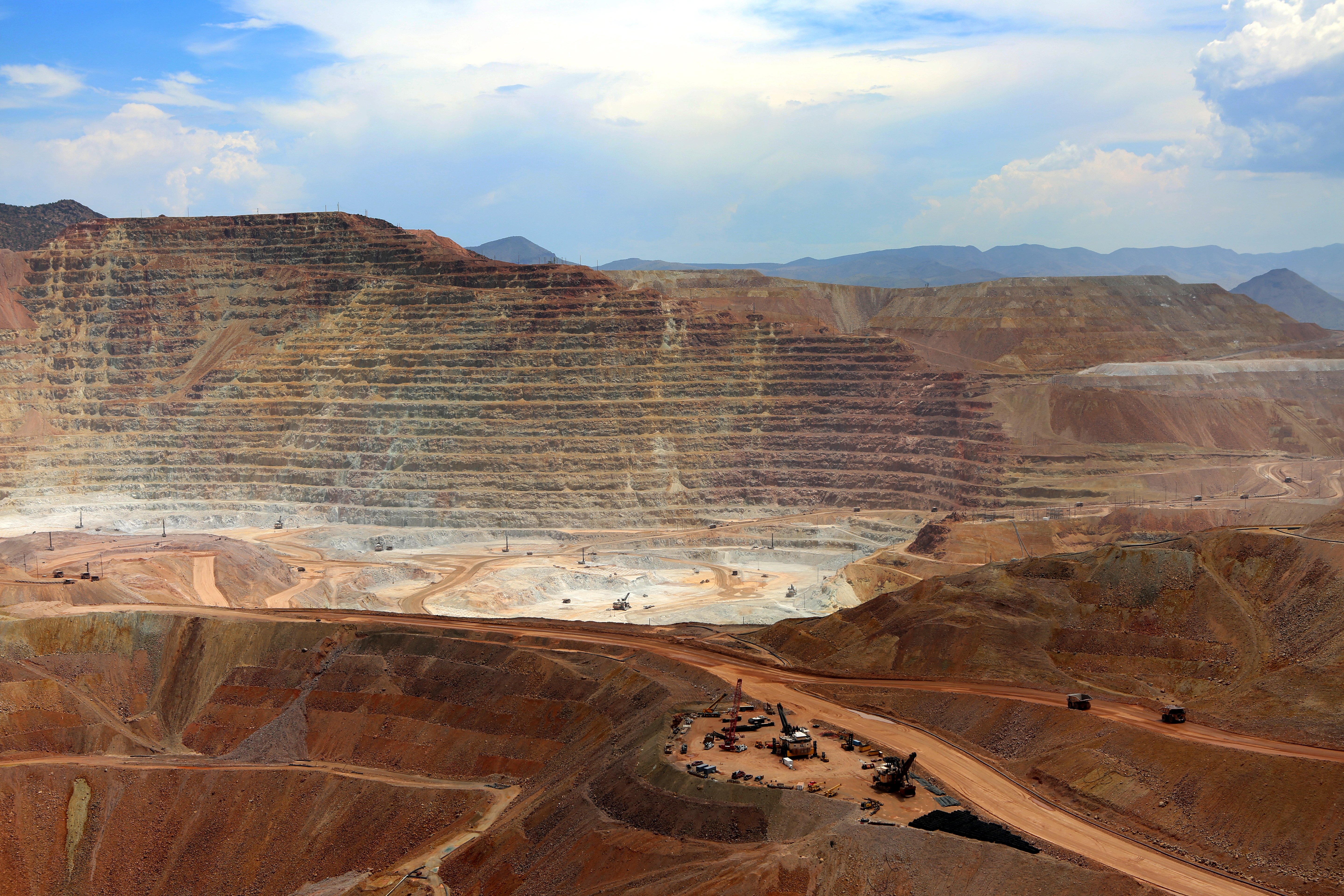 large open pit mining site showing terraced excavation and land disruption from surface mining