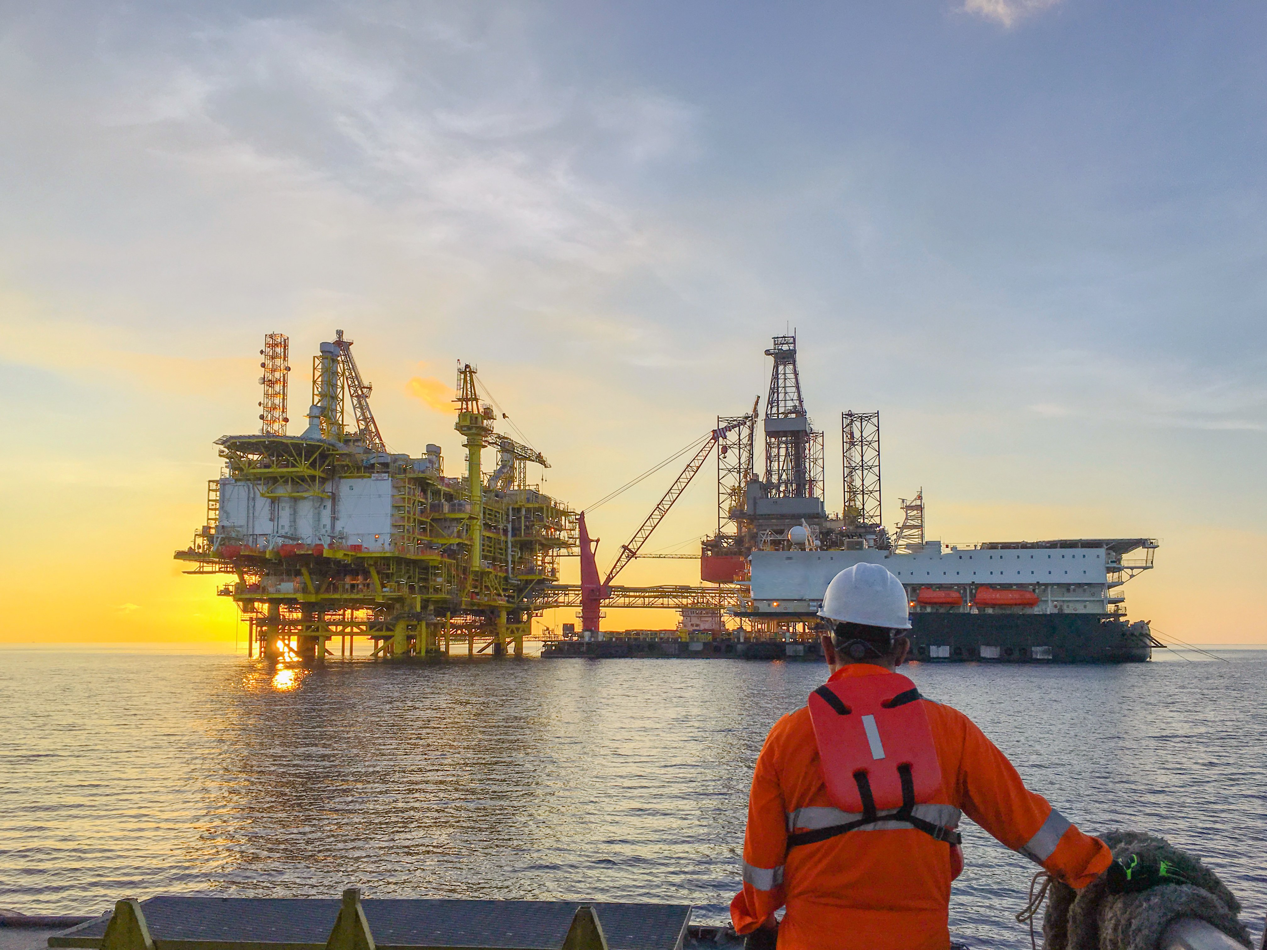 Offshore oil rig platform in open water at sunset representing offshore oil rig jobs and offshore oil drilling jobs
