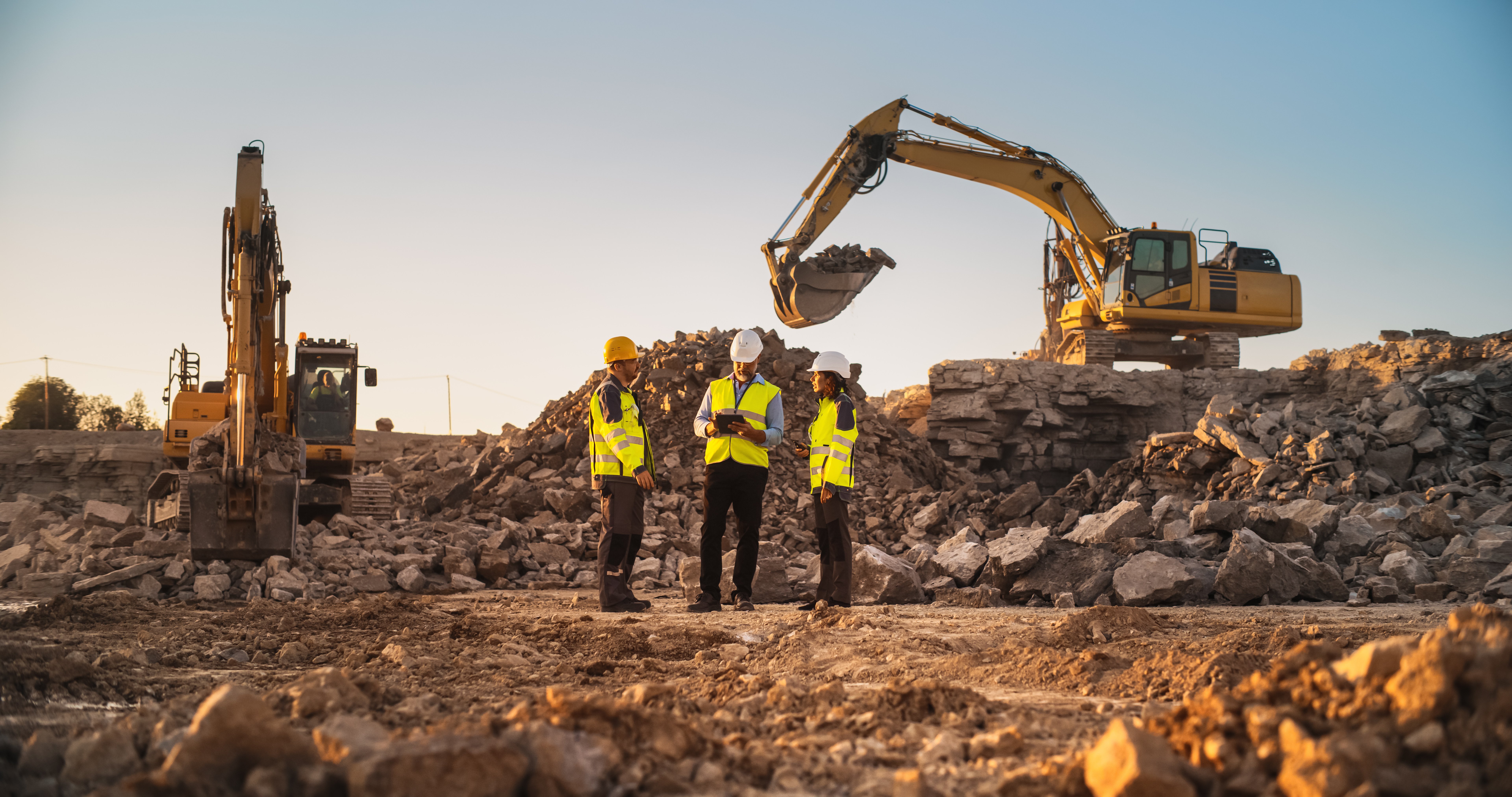 mining team reviewing excavation site with heavy equipment representing surface vs subsurface mining methods