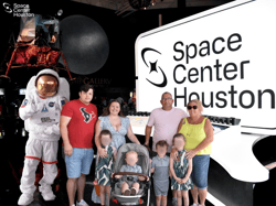 Josh Dean, a Brunel UK recruiter who relocated to the US, stands with his family at Space Center Houston