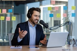 Male sits in office as he contributes to podcasts for professional development