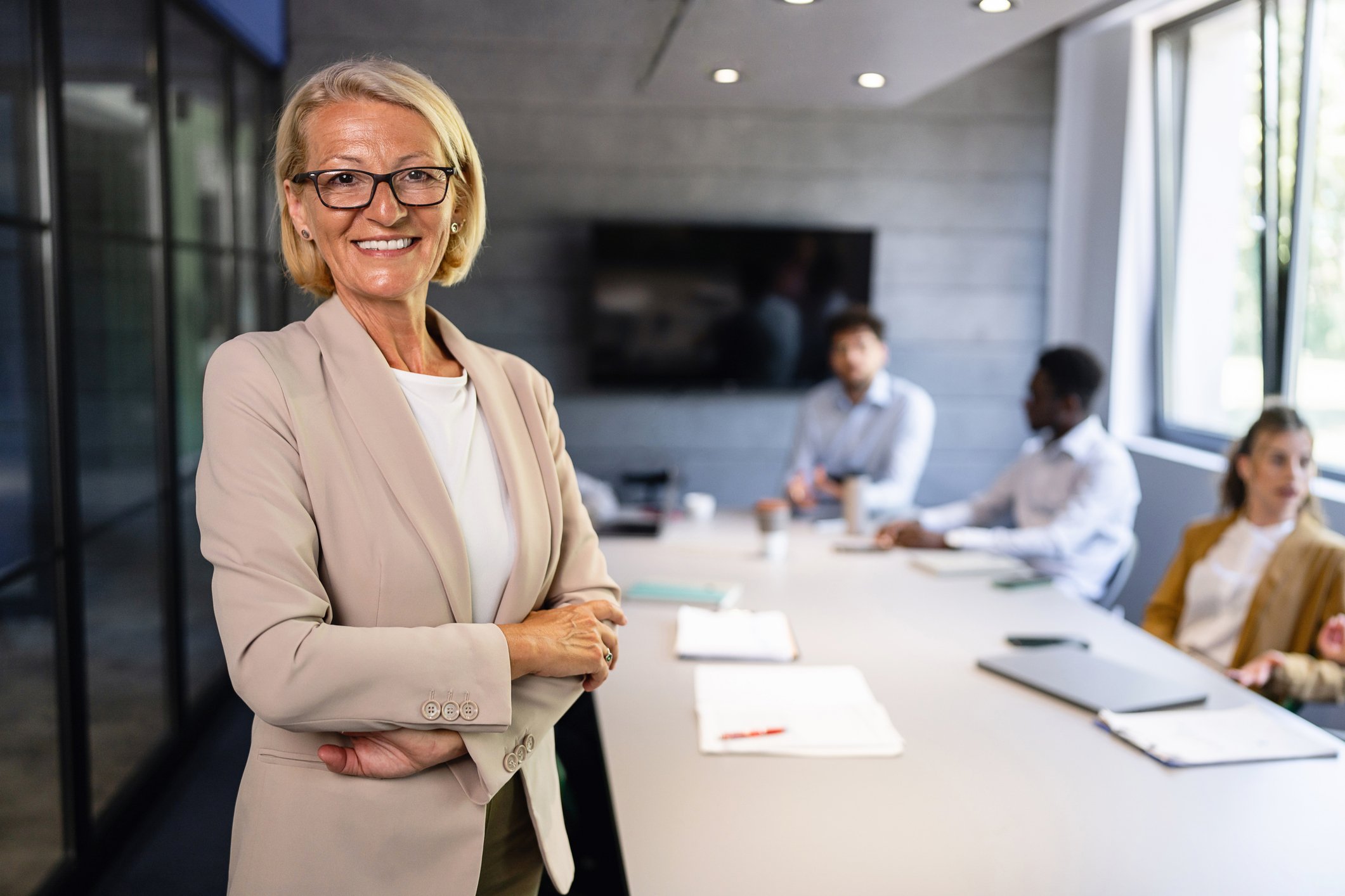 Seasoned female professional smiles in front of team in an office setting to show her enthusiasm as projetc manager career paths grow in the energy industry