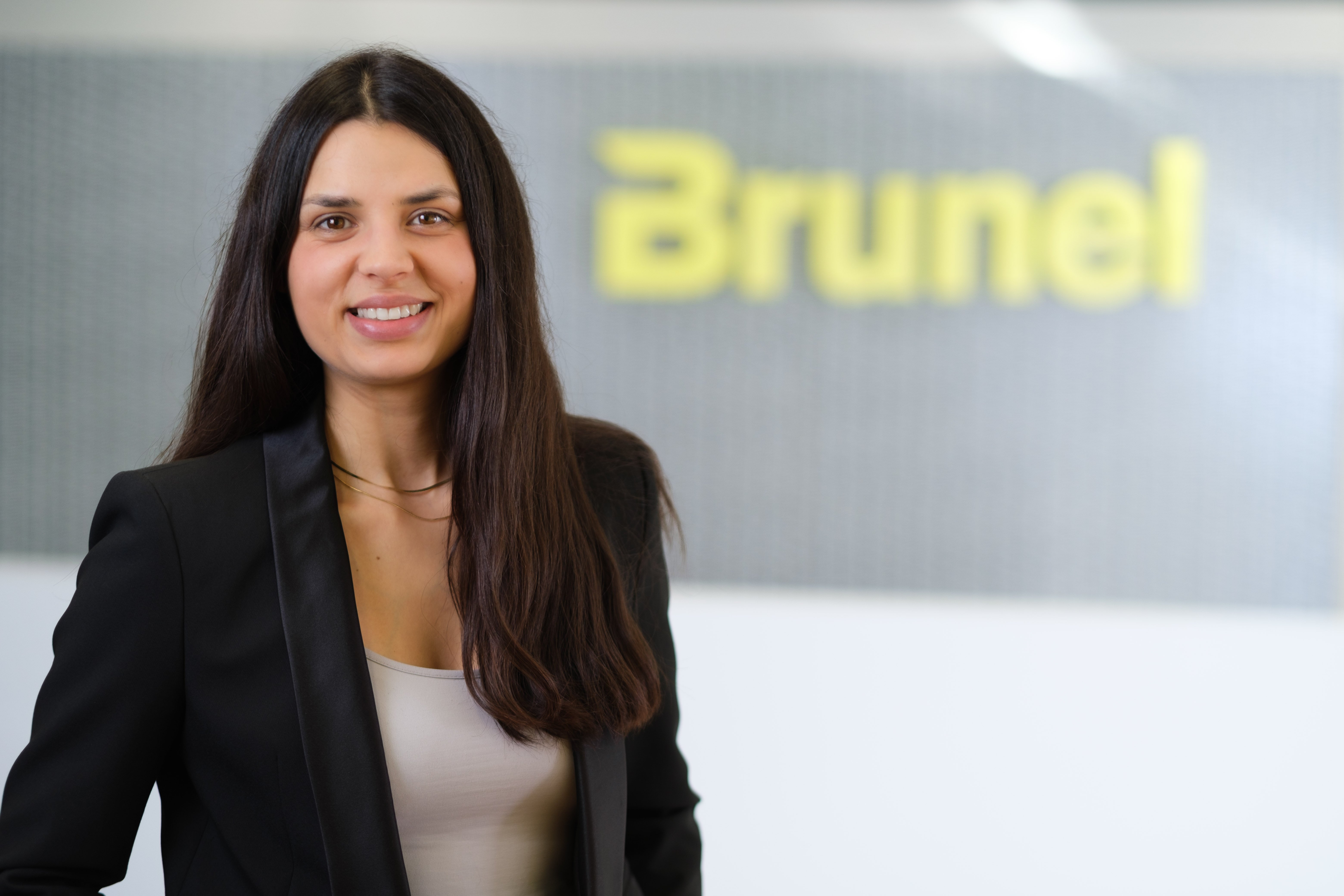 Porträt von junger frau mit langen schwarzen Haaren vor Brunel Logo.