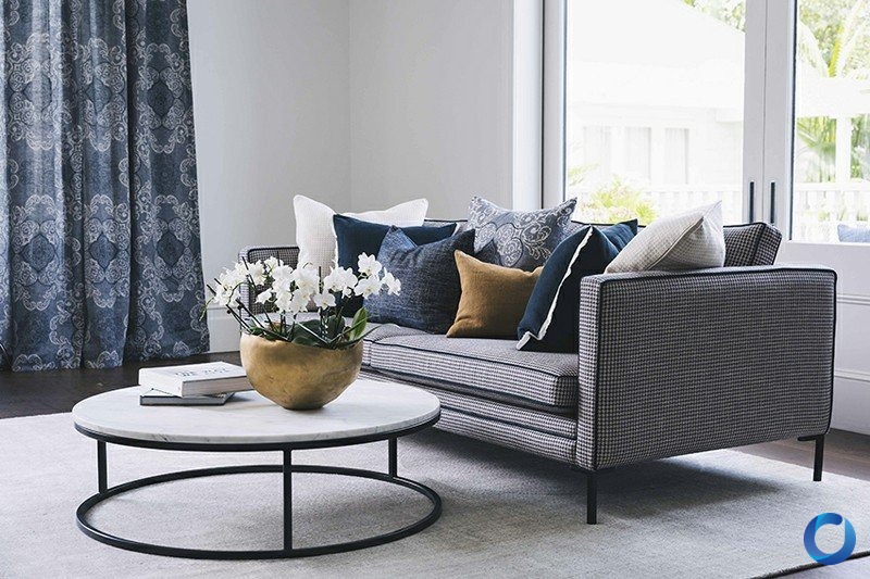 Navy patterned curtain beside a grey houndstooth sofa styled with navy and mustard cushions, James Dunlop Heritage collection