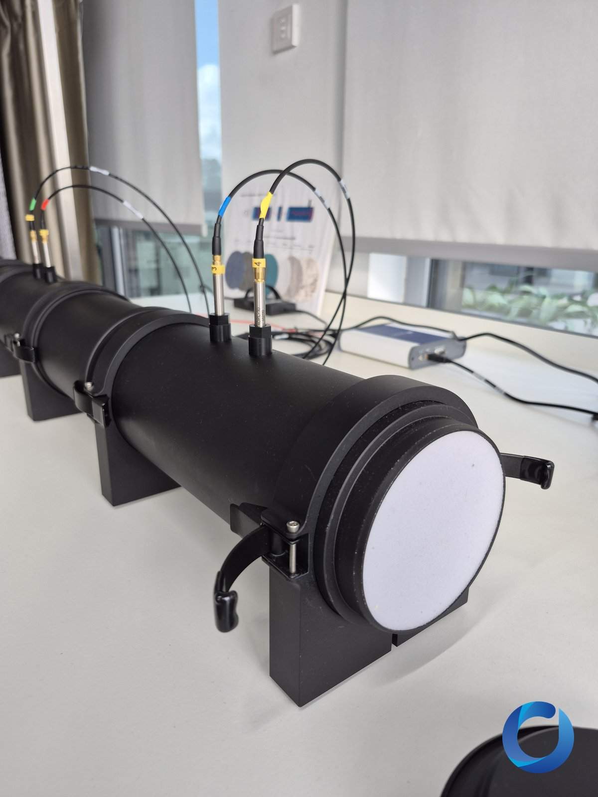 Acoustic impedance tube with measurement microphones and a fabric sample disc in the laboratory