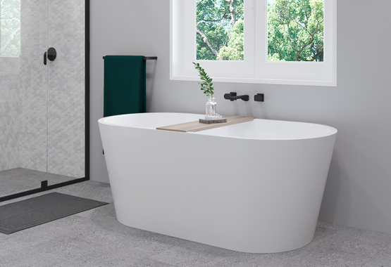 Large white bathtub with black tapware