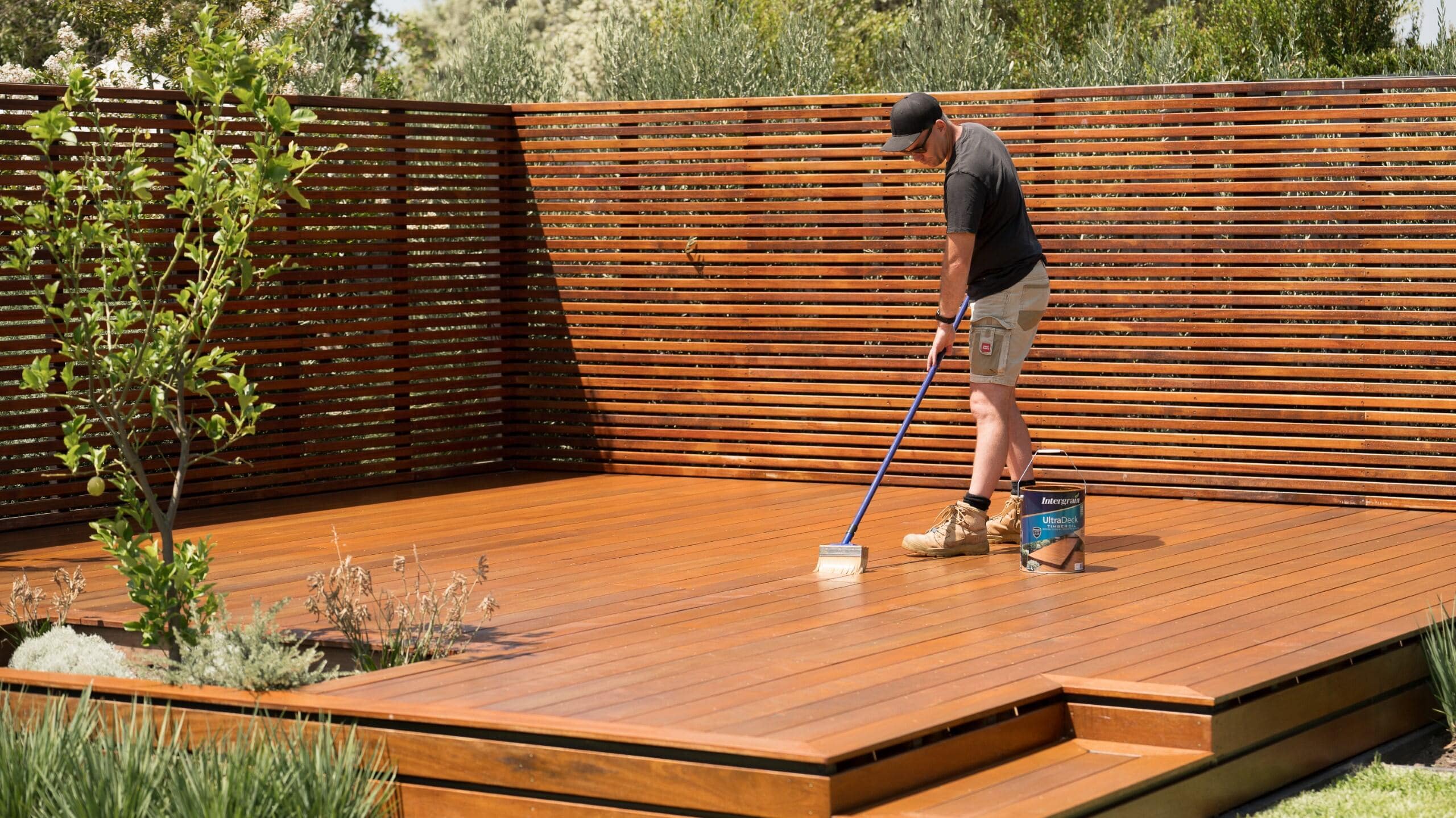 man applying second coat to merbau
