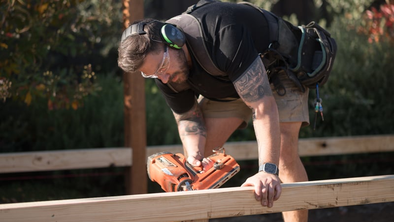 Holding a piece of timber and a nail gun