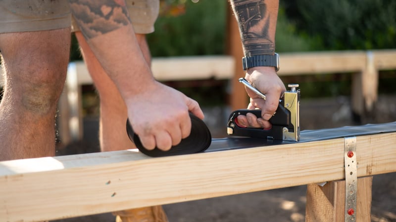 Attaching rubber to bearers using a staple gun
