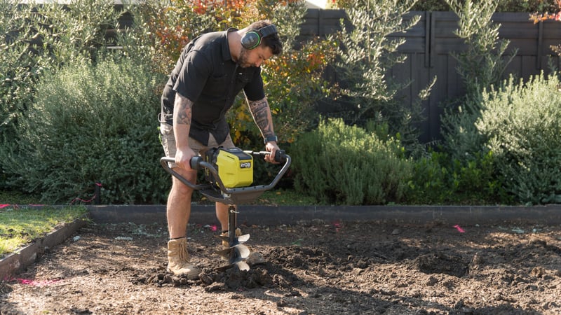 A person is digging the holes using a hole digger