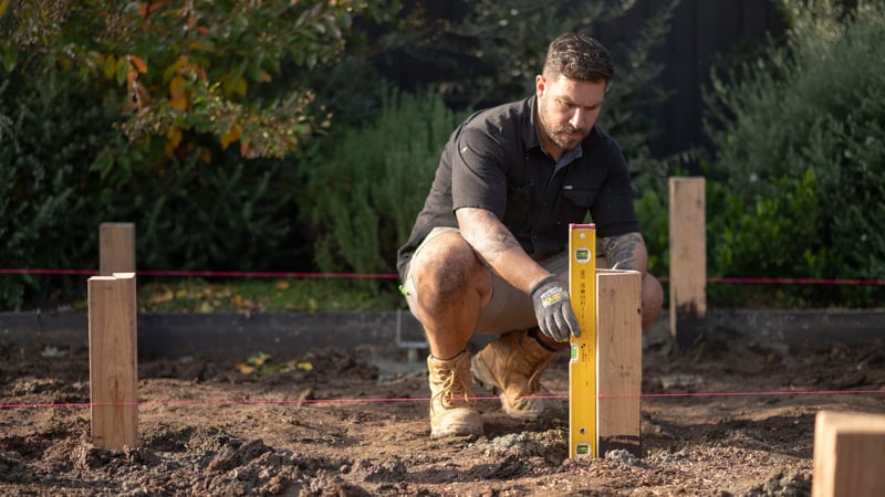 Using a spirit level to ensure all the stumps are the same height