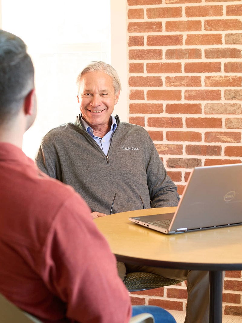 man with laptop discussing with customer