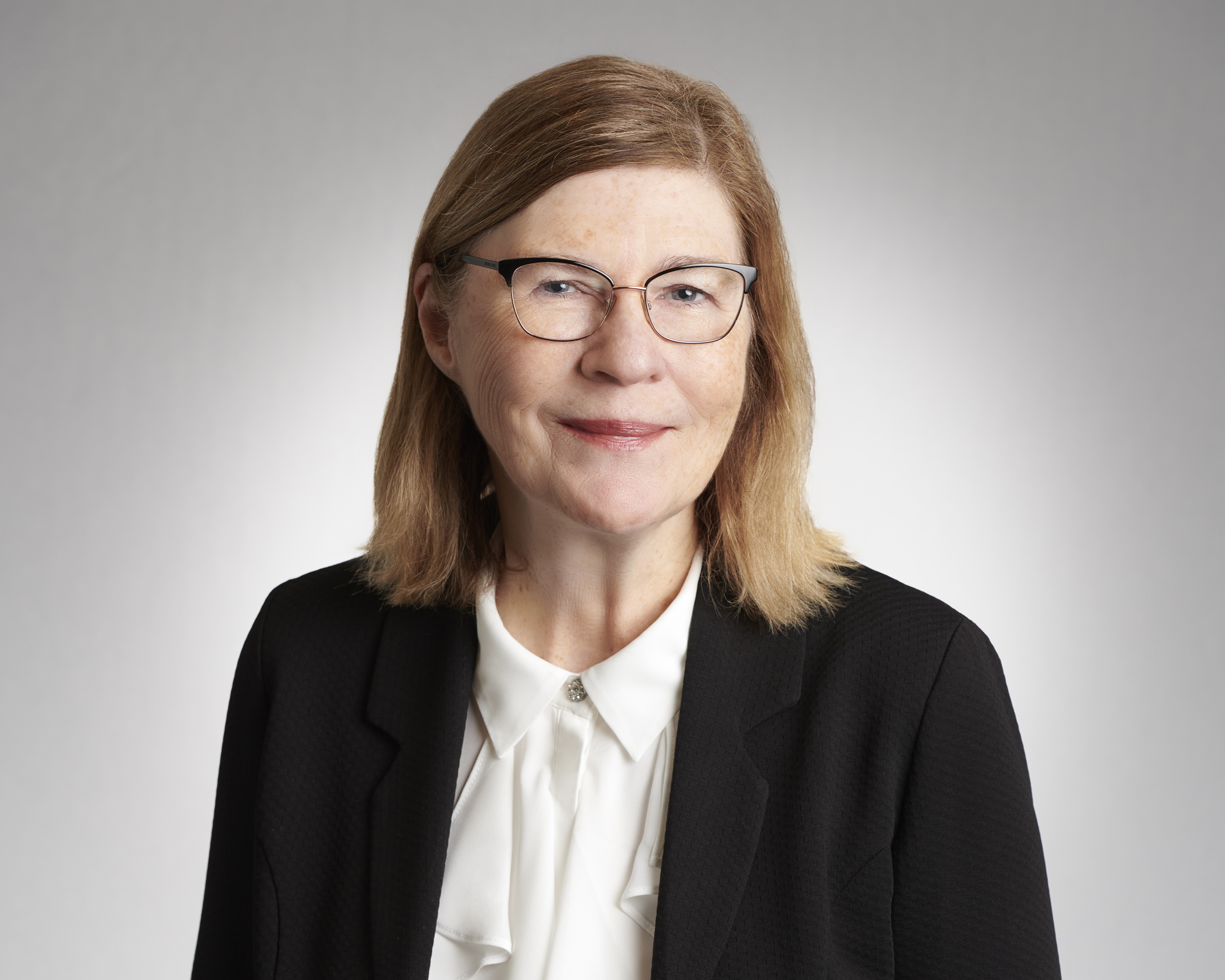 Professional headshot of Joan Weir with a calm expression