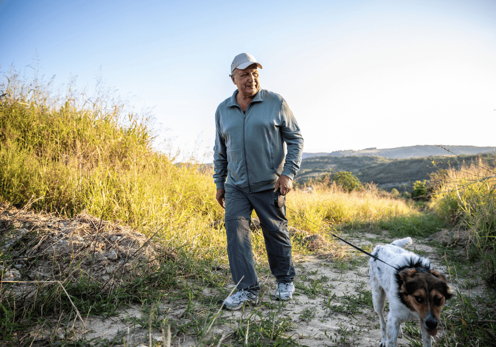 Retiree walking his dog in the field