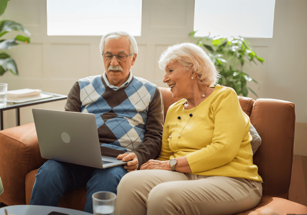 Retirees looking at the laptop smiling