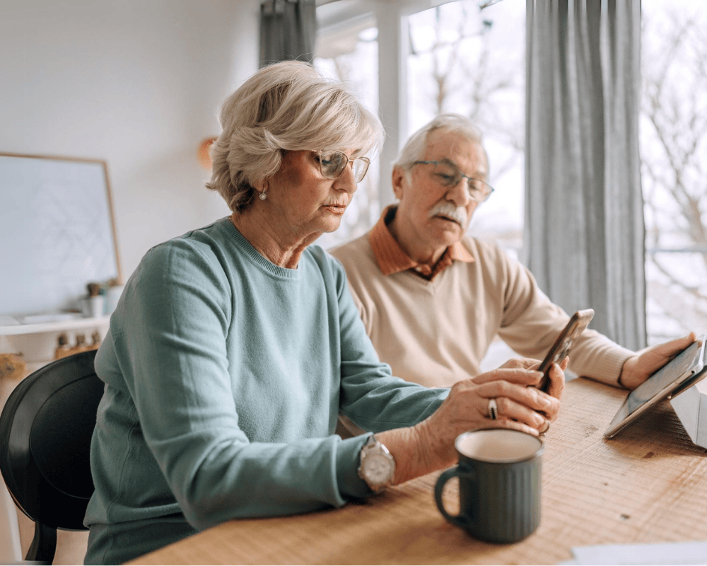 Retiree couple looking at the phone at home