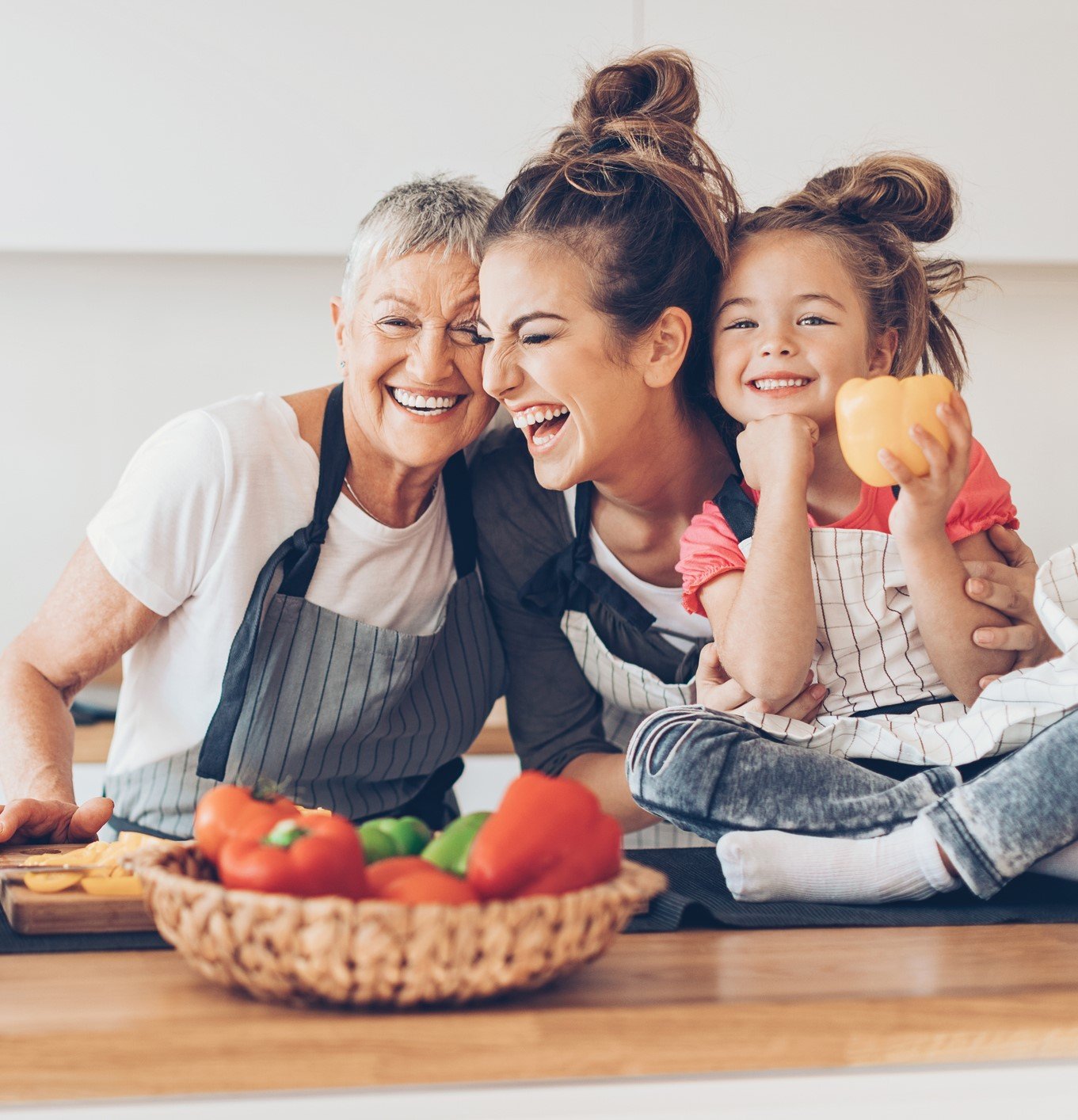 Three generations women laughing in the kitchen