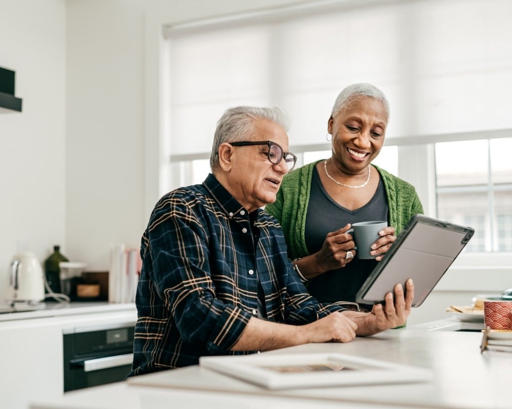 Retiree Couple Looking at information on Tablet Happily