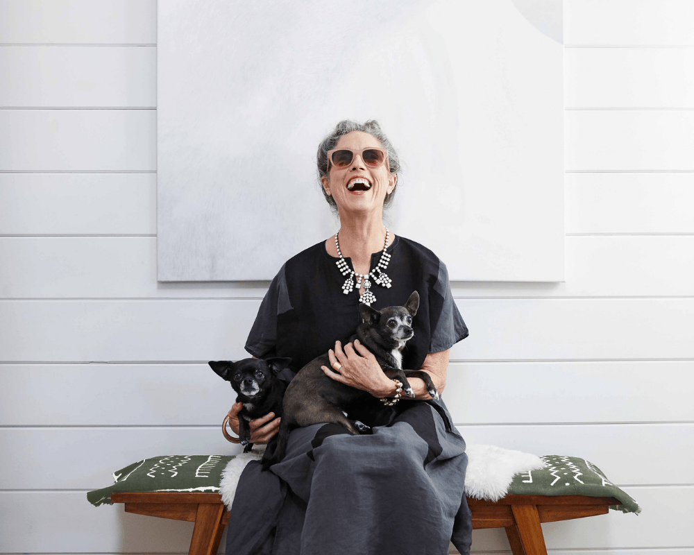 Women laughing with her dogs on her lap
