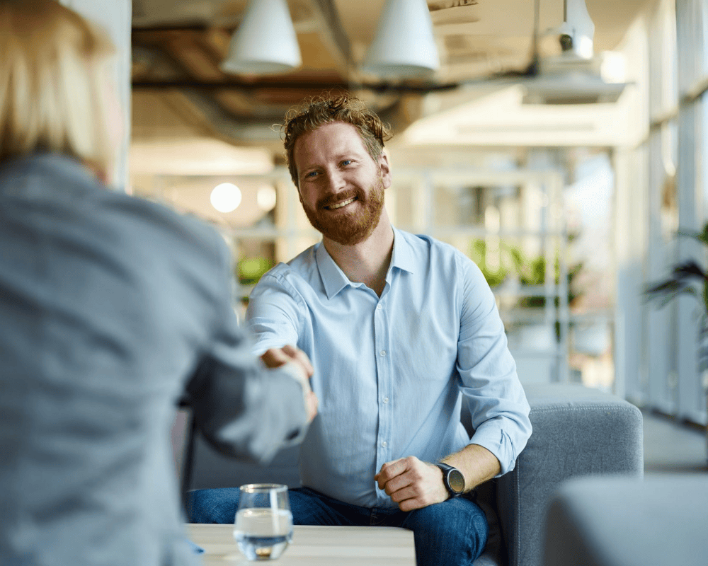Happy businessman shaking hands with his colleague at casual office