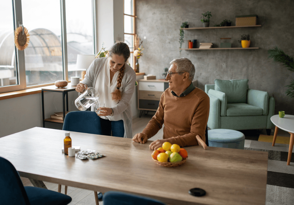 Retirees daughter pouring a glass of water for her dad