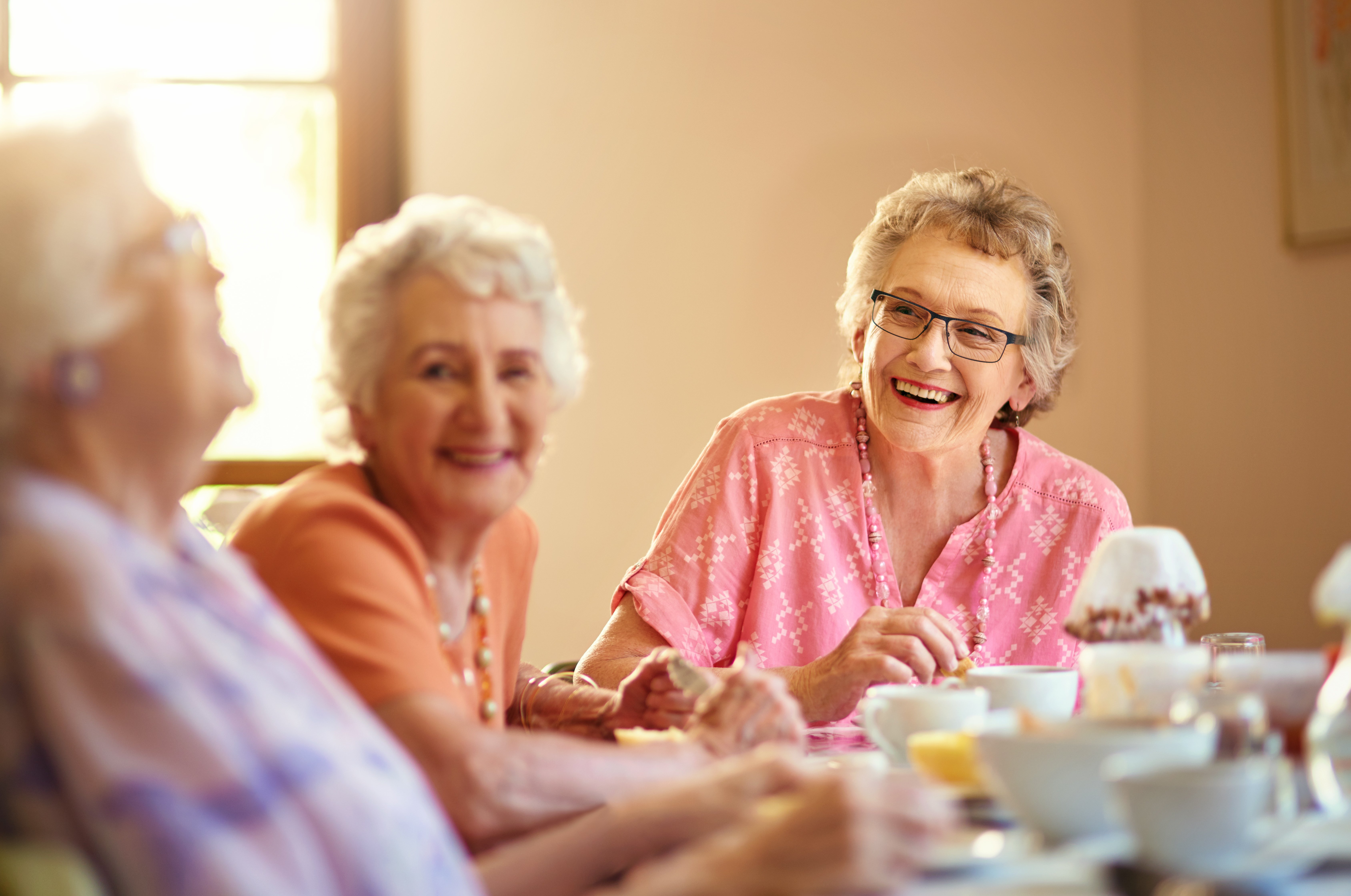 Elderly Women Laughing Together Over Tea