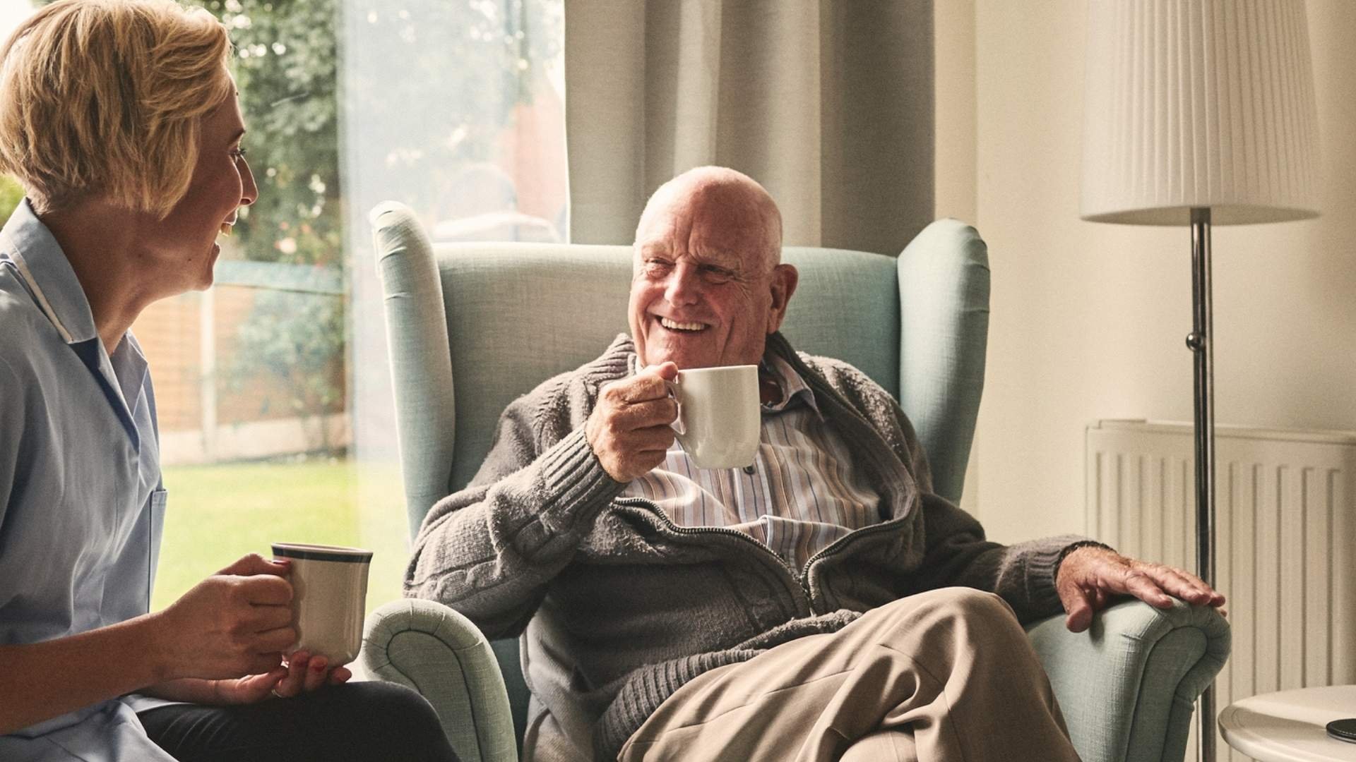 Elderly couple sitting drinking tea happily