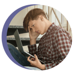 A photo of a child looking frustrated holding a computer