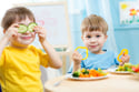 Two boys eating vegetables