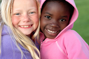 Photo of two smiling girls wearing hoodies