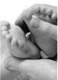baby receiving a foot massage from parents