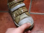 close up of child's shoe with person pressing on the toe