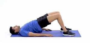 man doing a bridge on a mat