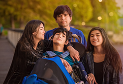 2805 - Brother and Sisters Surrounding Disabled Boy in Wheelchair at Park