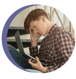 A photo of a child looking frustrated holding a computer