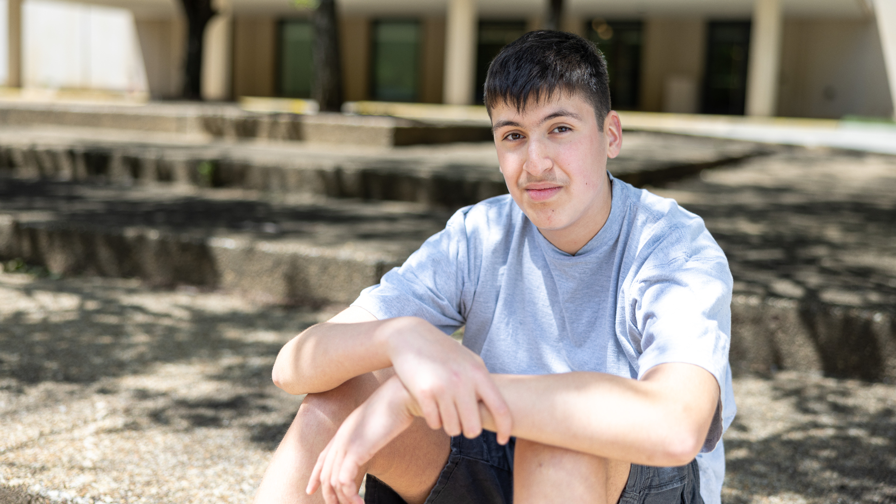 teenaged boy sitting outside