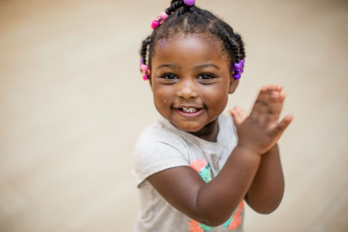 Young girl smiling and clapping
