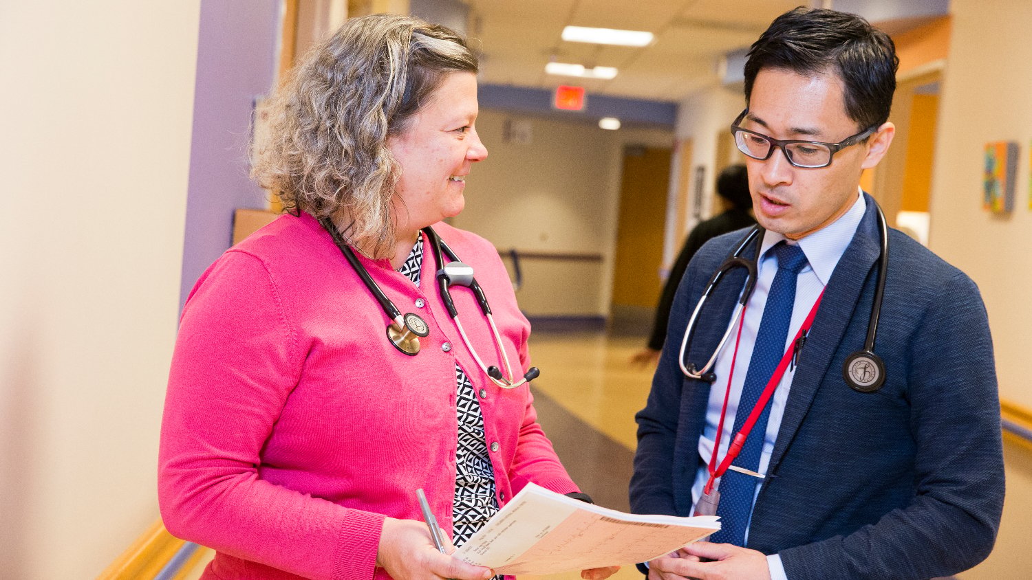 healthcare providers have discussion in hospital hallway