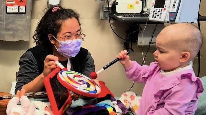 Music therapist playing instruments with a young patient